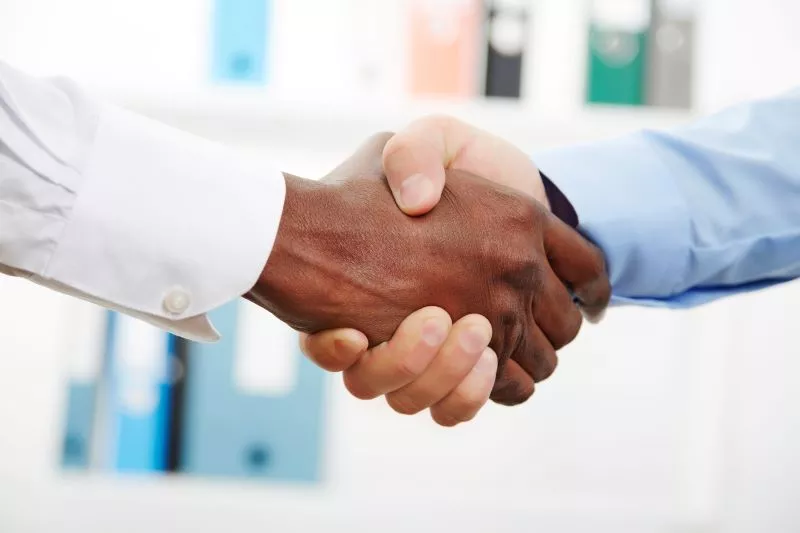 Ръкостискане между бизнес партньори като жест на постигнато съгласие за финансиране в подкрепа на инициативи, които подпомагат грижата за здравето.